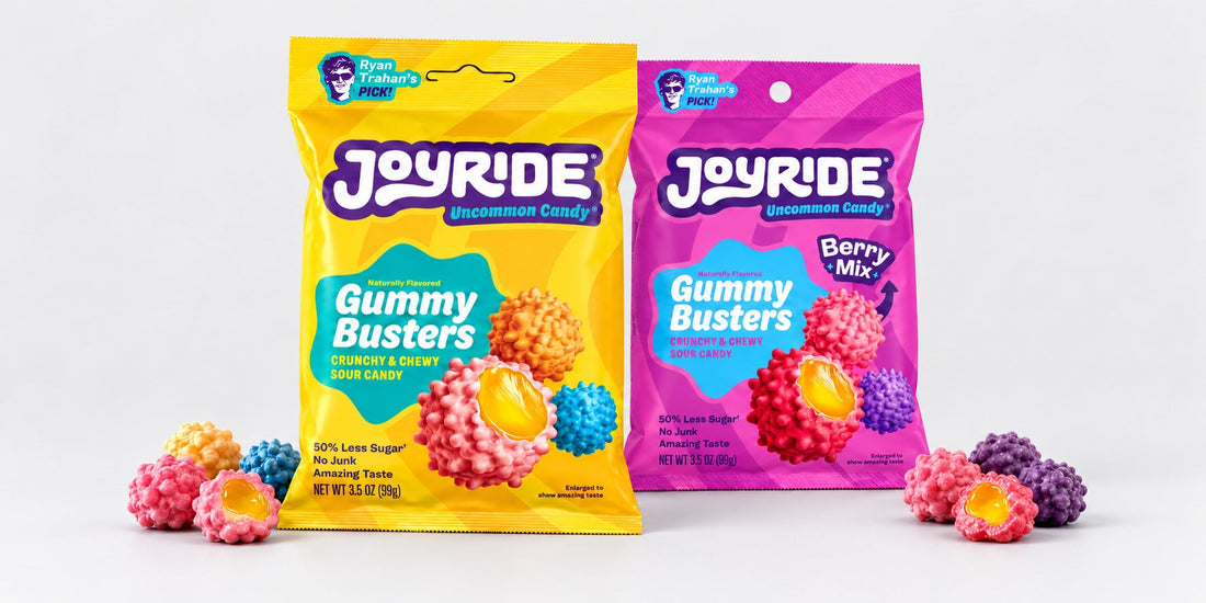 Original and Berry JOYRIDE Gummy Busters with loose candy on a plain pale-grey studio backdrop